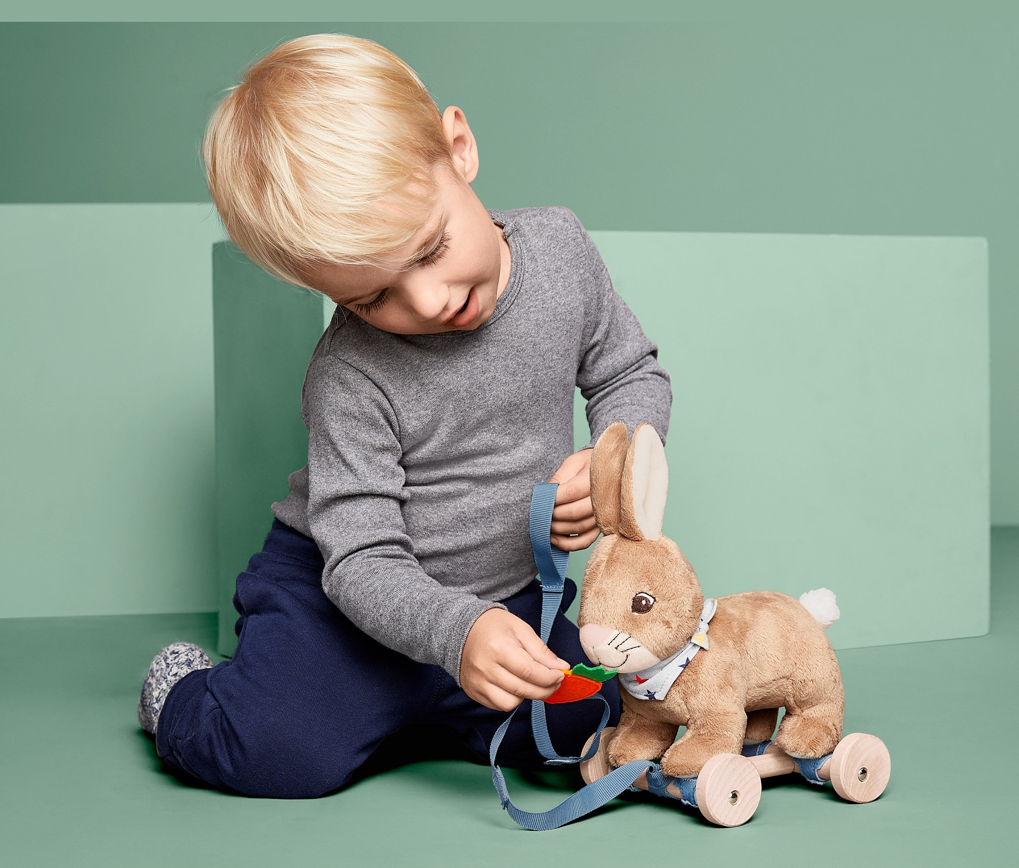 Oğlan Tekerlekli Oyuncak »Zıplayan Tavşan« ile oynuyor.