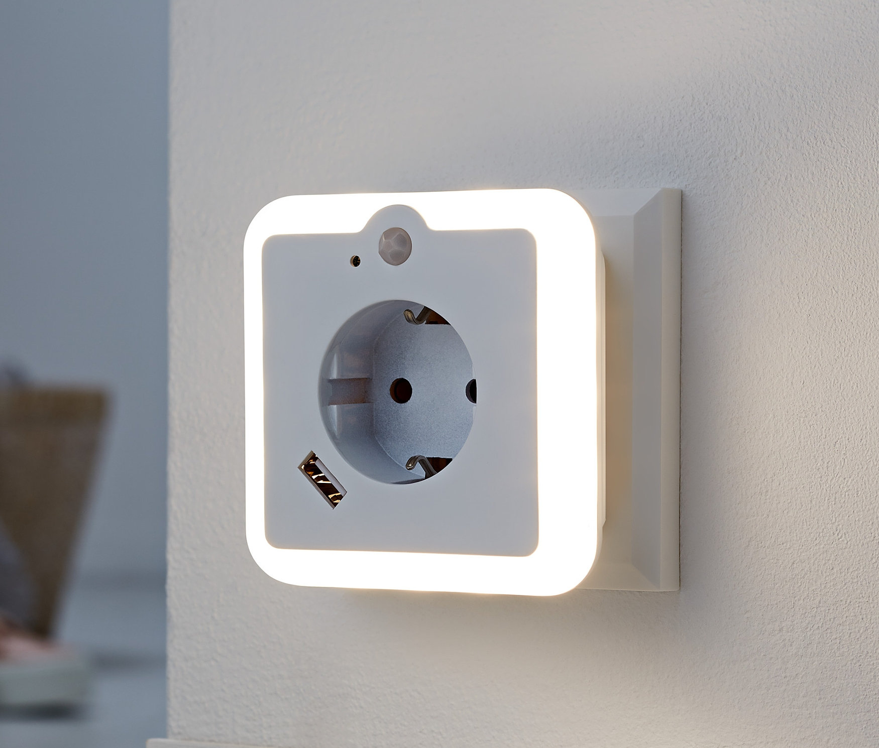 Beyaz duvarda prizli ve USB şarjlı LED gece lambası.