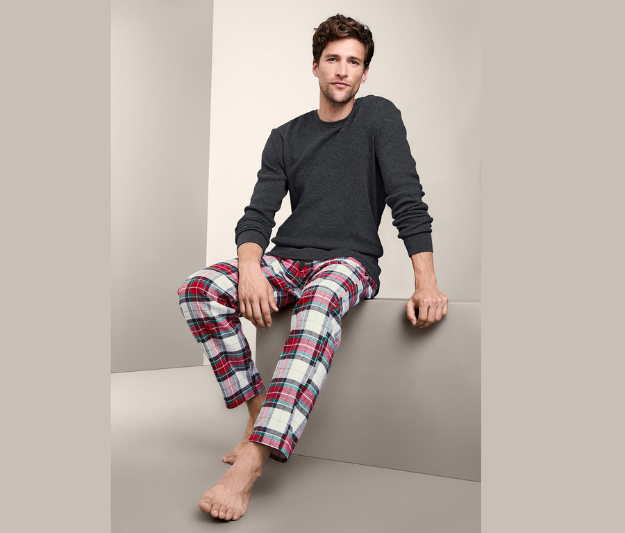 Adam oturuyor ve Flanel Altlı Pijama Takımı giyiyor.