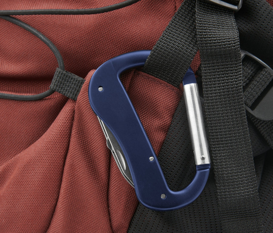 Mavi bir 5'i 1 Arada Karabina Çok Amaçlı Alet bir sırt çantası kayışına asılı duruyor.