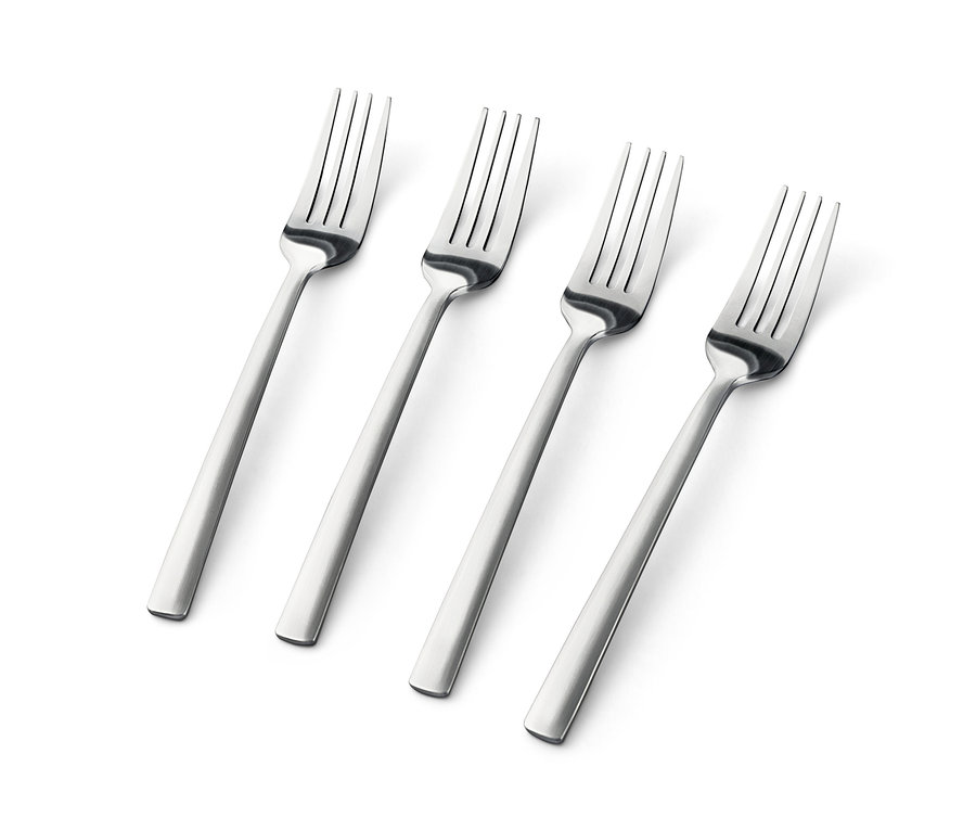 Beyaz bir arka plan üzerinde çapraz olarak duran dört adet gümüş renkli pasta çatalı.