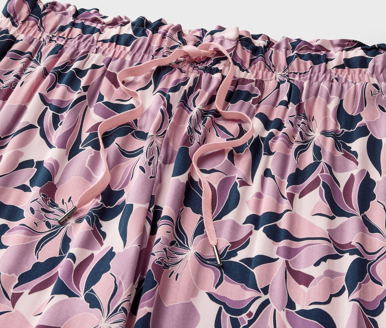 Çiçek desenli ve bağcıklı rahat pantolonun yakın çekimi.