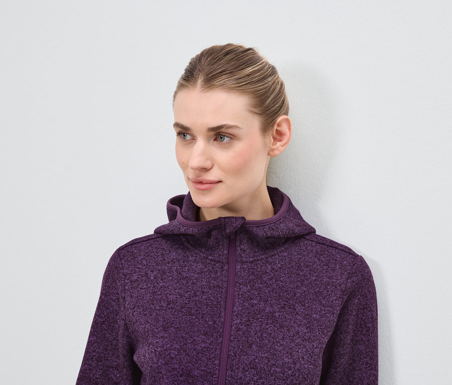 Mor kapüşonlu sweatshirt giyen sarışın bir kadının portresi.