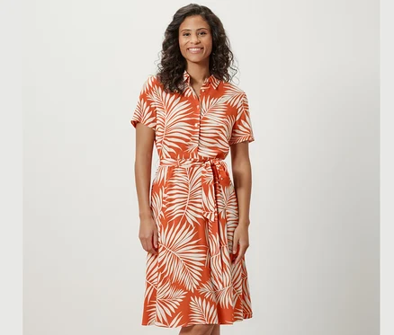 Kadın desenli gömlek elbise giyiyor.