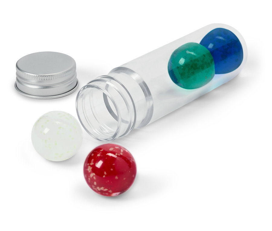 Şeffaf bir tüp, içinde mavi ve yeşil bir bilye, yanında gümüş bir kapak ve dışında beyaz ve kırmızı bir bilye ile yan yatıyor.