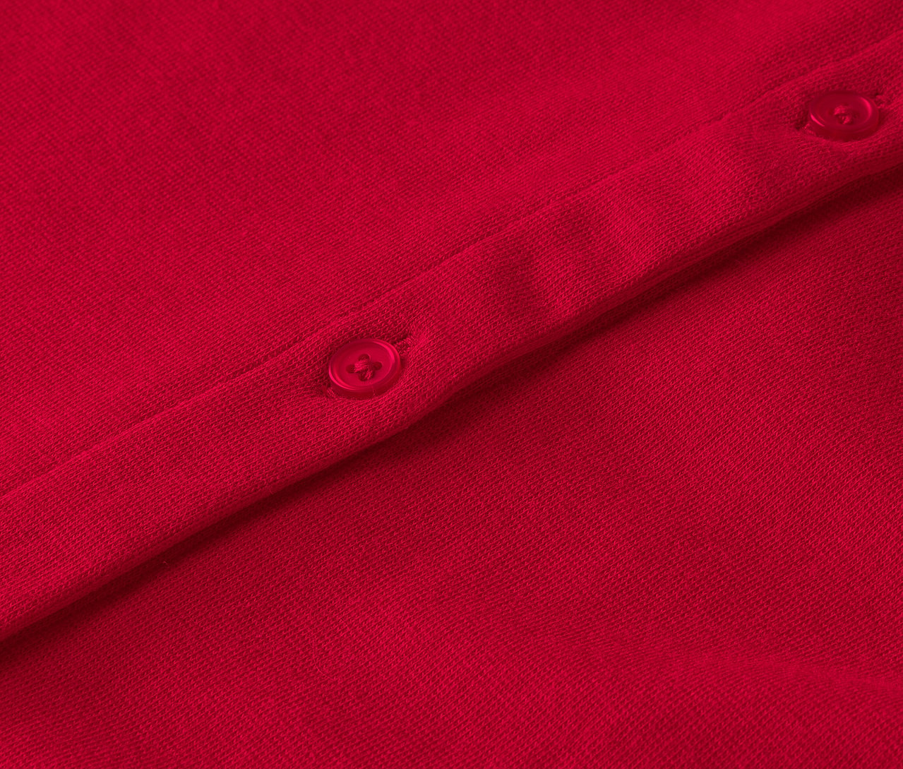 Düğmeli kırmızı bir giysinin yakın çekimi.