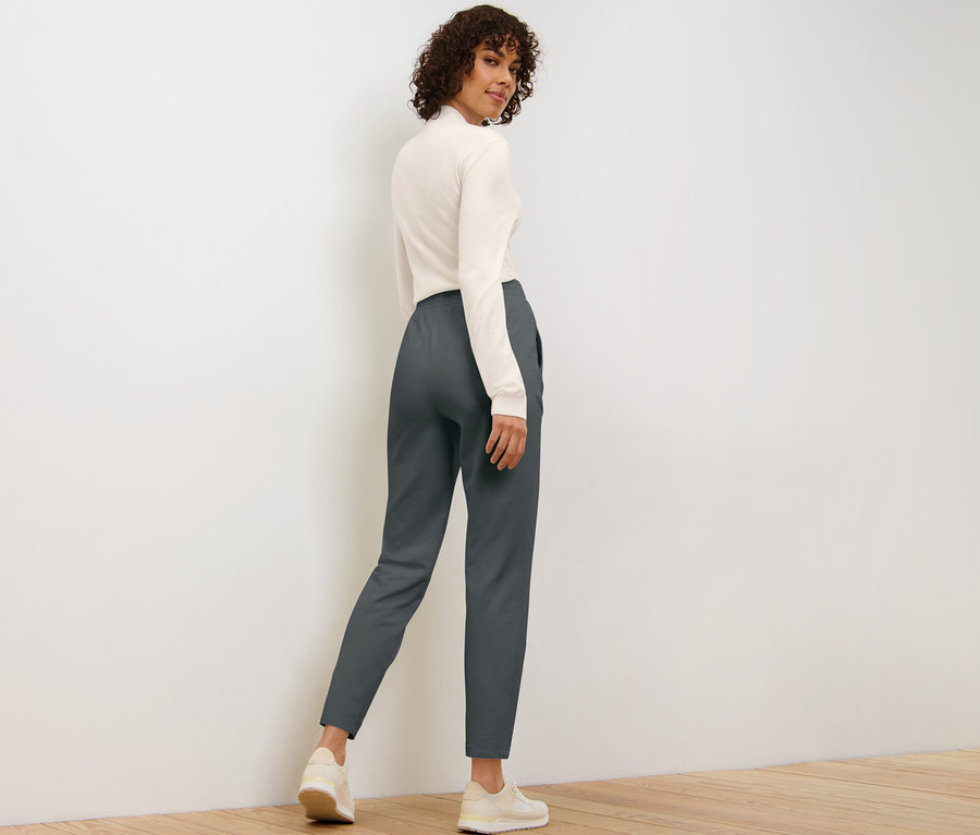 Kadın omzunun üzerinden bakıyor ve eşofman altıyla poz veriyor.