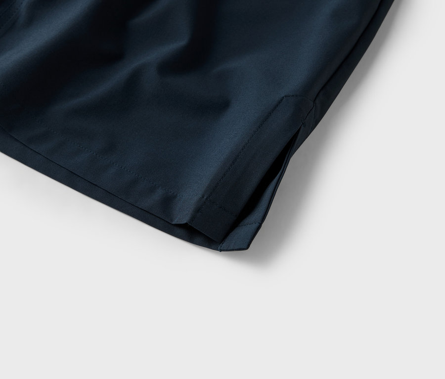 Beyaz bir arka plan üzerinde lacivert şortun cebinin yakın çekimi.