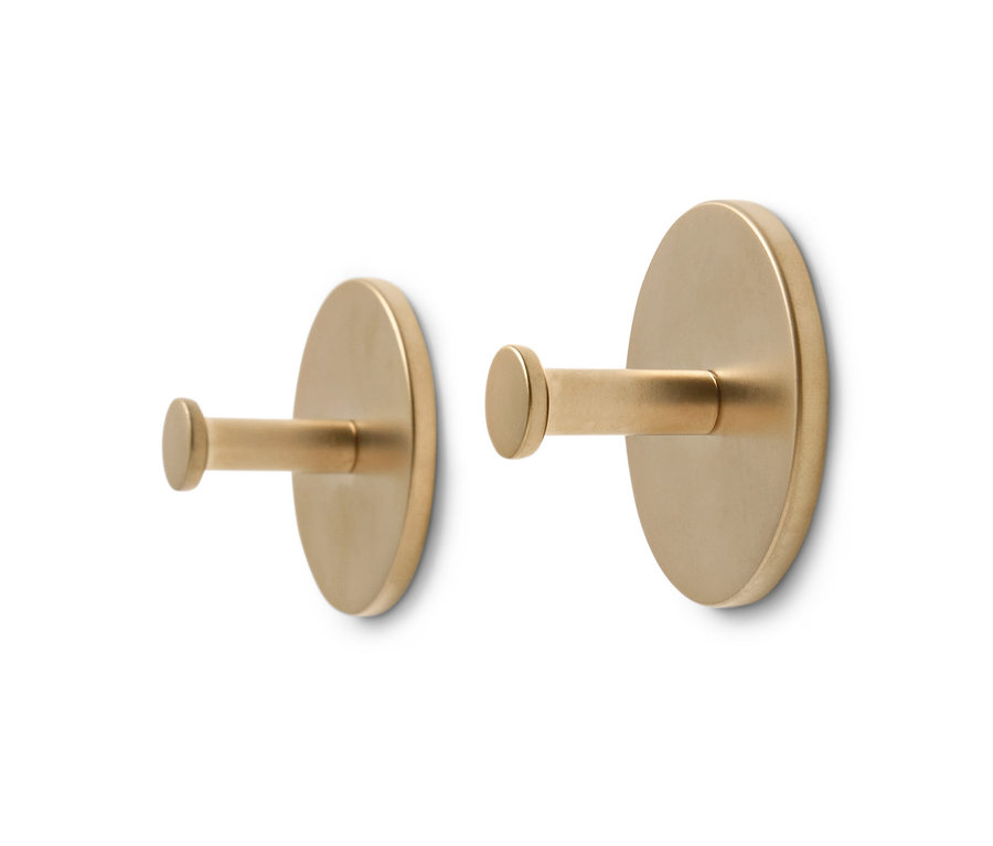 Beyaz bir duvarda iki altın rengi kanca