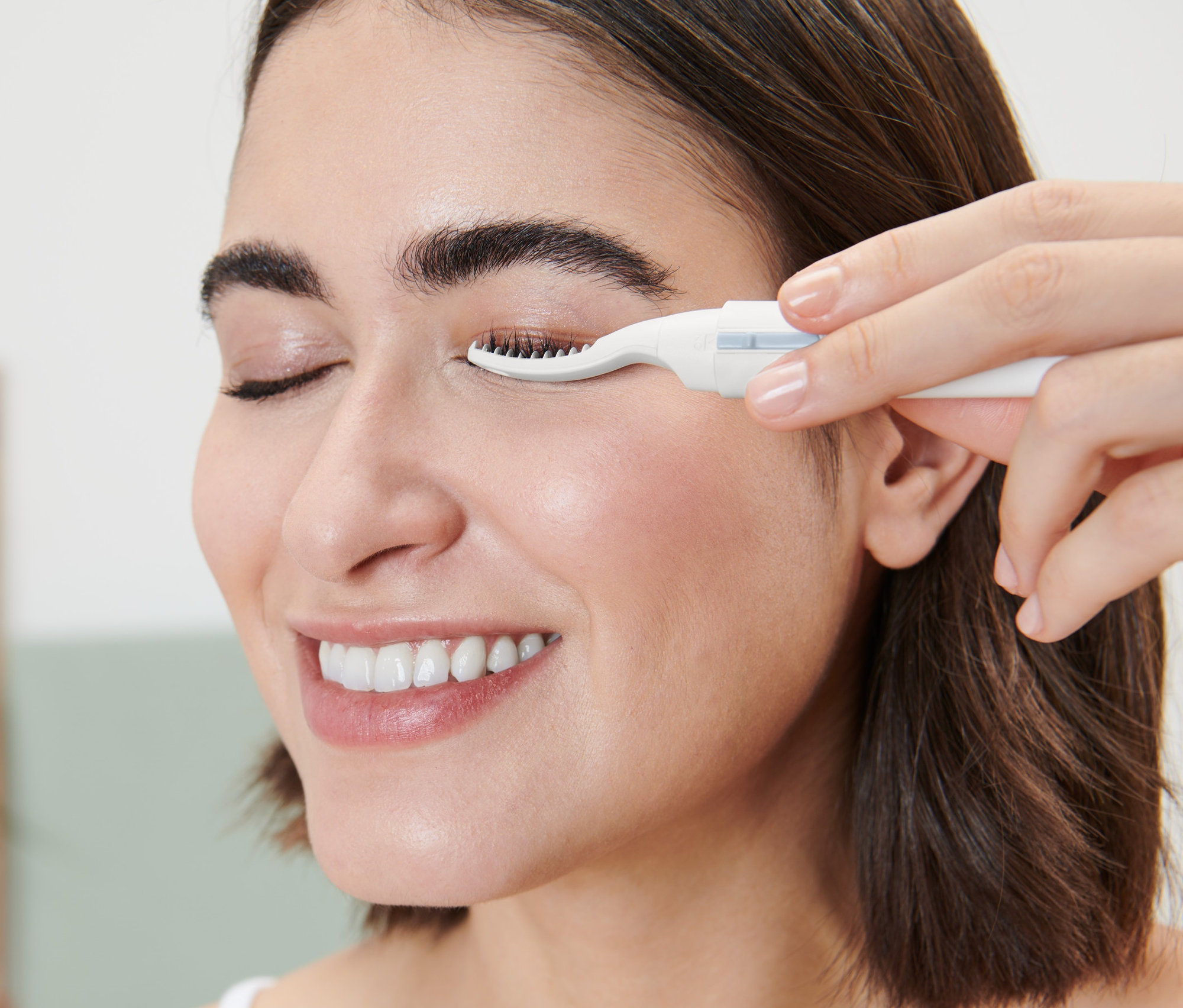 Kadın ısıtmalı kirpik kıvırıcı kullanıyor