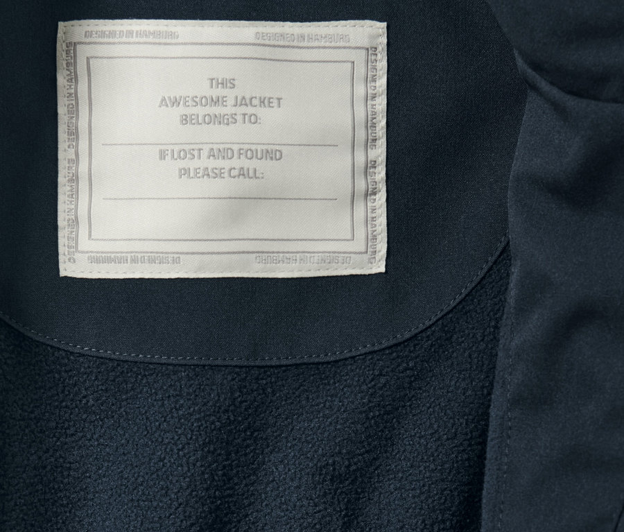 'THIS AWESOME JACKET BELONGS TO:' etiketli çocuk yağmur parkası detayı.