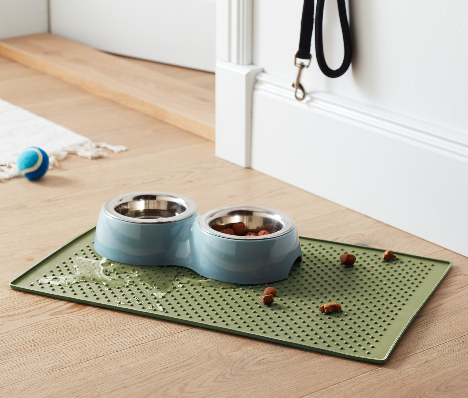 Mama kabı altlığının üzerinde mama bulunan ikili mama kabı duruyor.