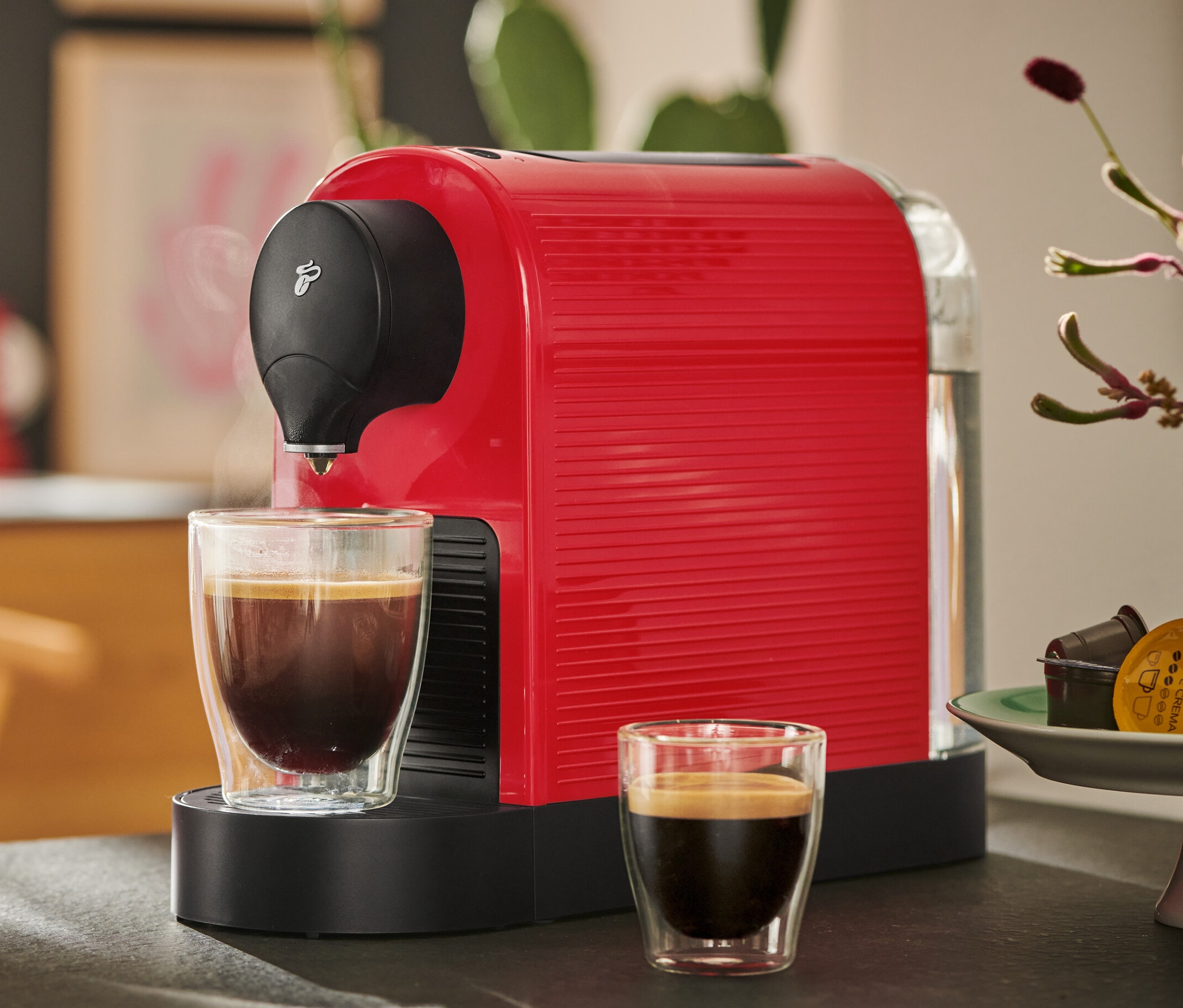 İki fincan kahve ile kırmızı Cafissimo Pure+ kahve makinesi.