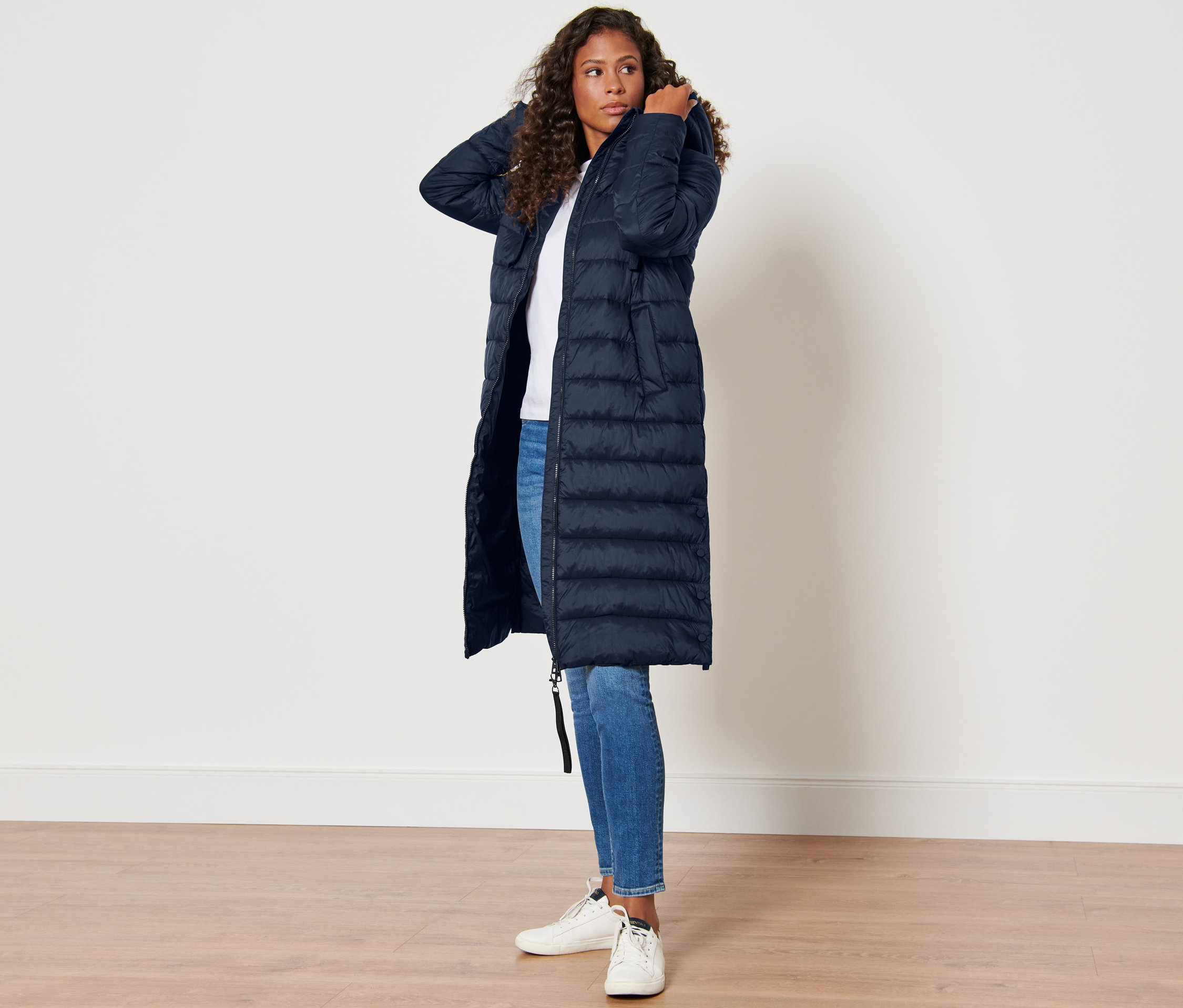 Kadın lacivert kapüşonlu kapitone montla poz veriyor.