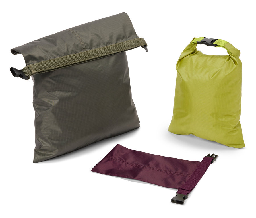 Zeytin yeşili, limon yeşili ve mor renklerde üç adet su geçirmez çanta beyaz bir zemin üzerinde duruyor.