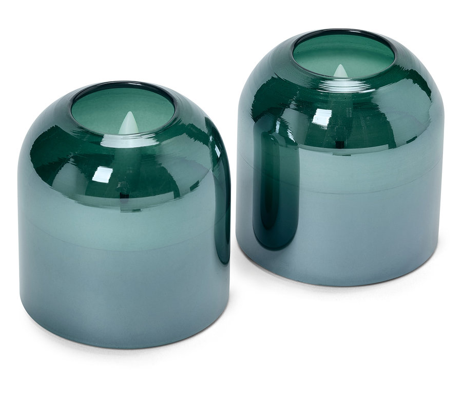 Beyaz bir arka plan üzerinde iki mavi ve yeşil cam mum.