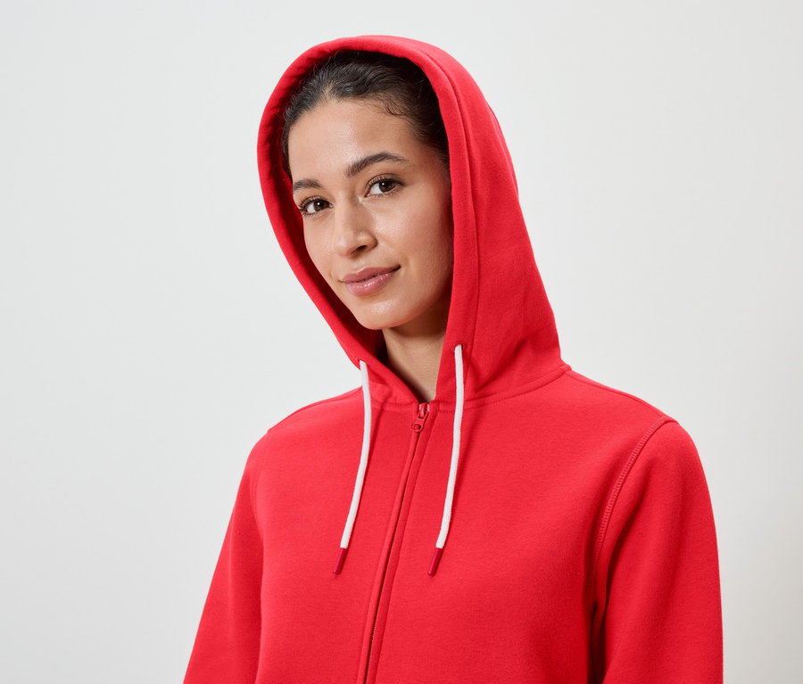 Kahverengi saçlı bir kadının kırmızı kapüşonlu ve beyaz ipli bir sweatshirt ile portresi.