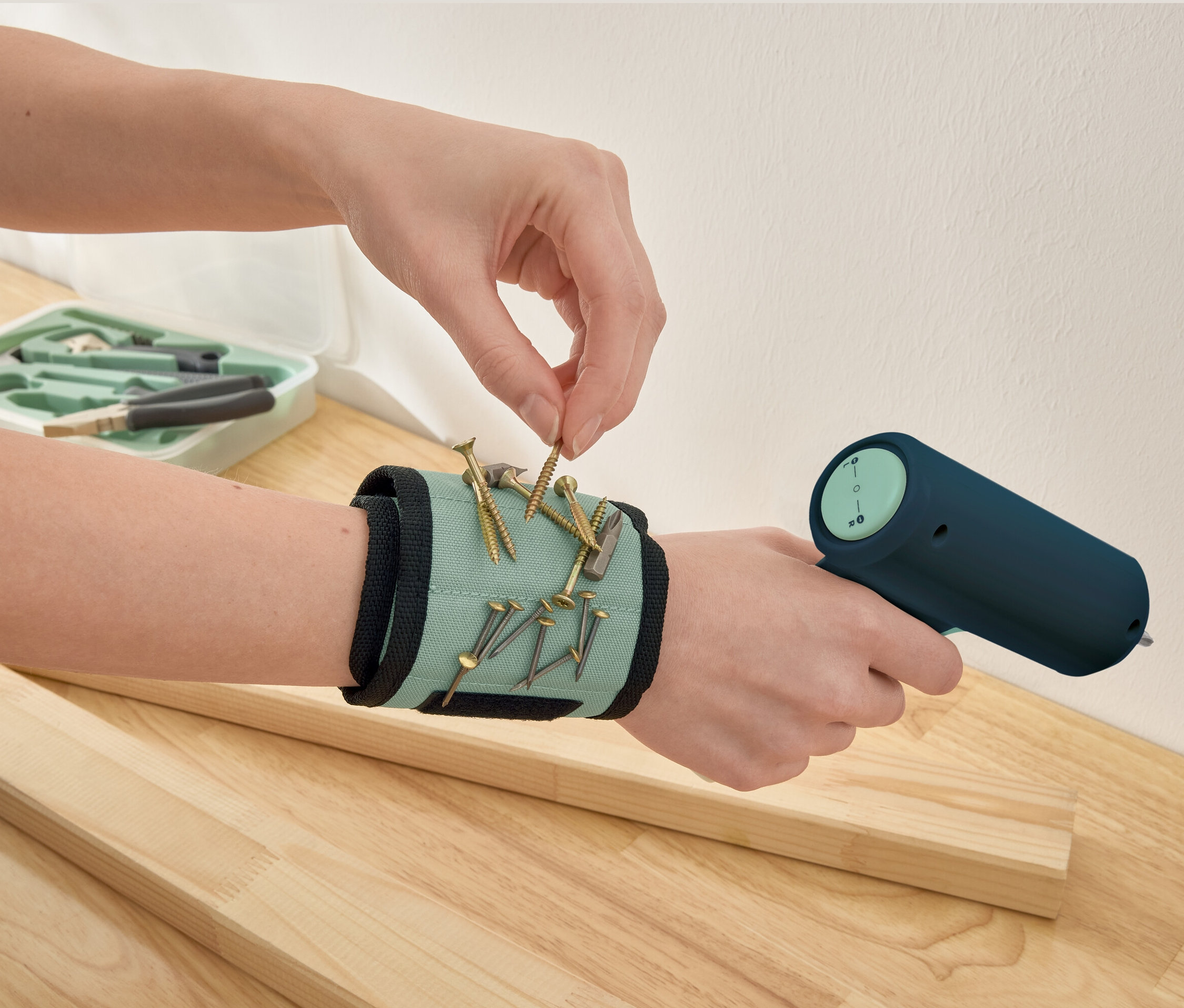 Bir el, mıknatıslı bileklikten bir vida alıyor.