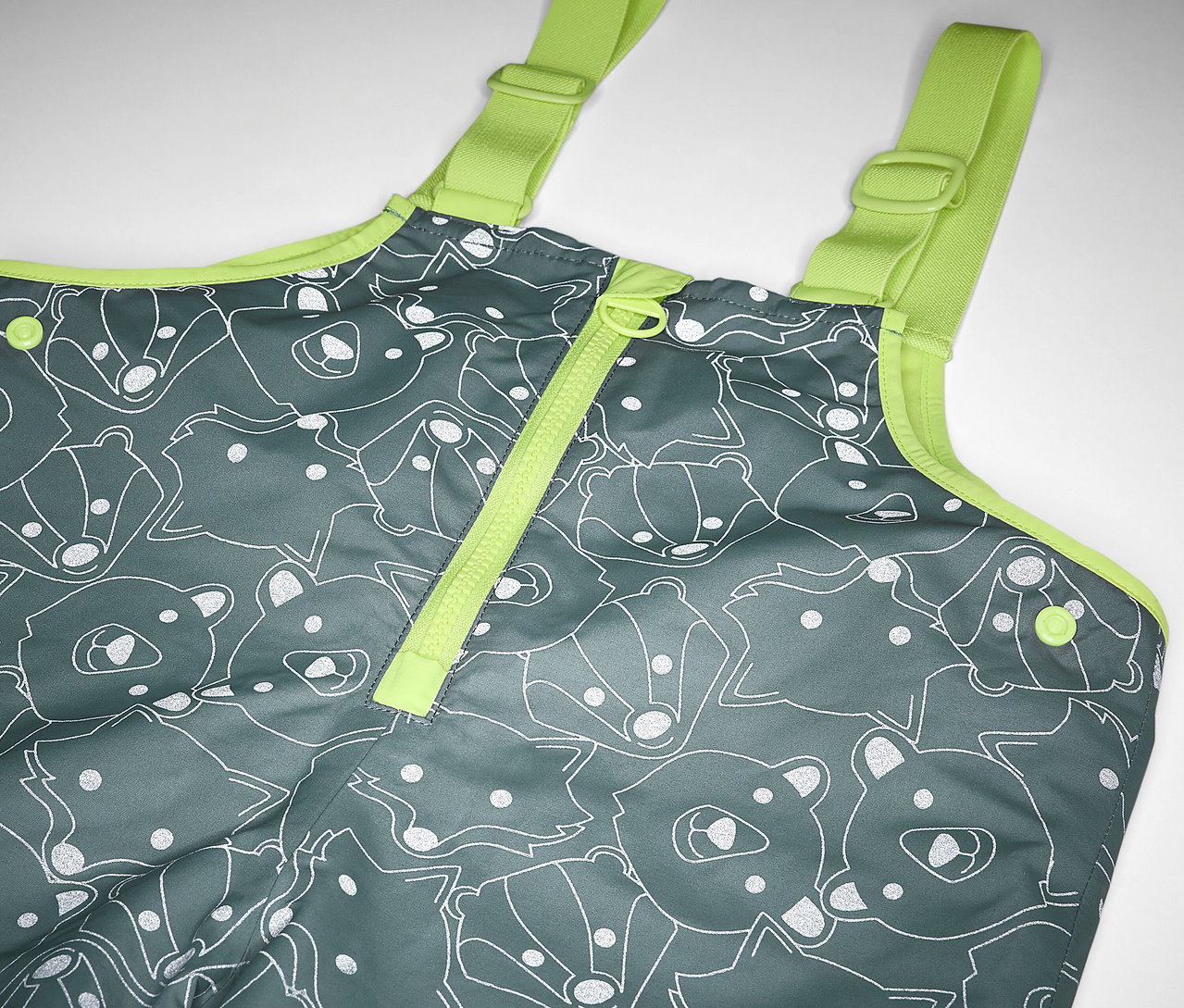 Çocuklar için reflektif detaylara sahip, ayı ve tilki baskılı gri renkli ve sarı askılıklı termal yağmur pantolonunun detayı.