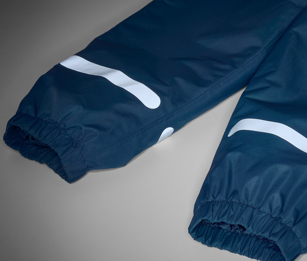 Reflektörlü çocuk termo yağmur pantolonunun yakın çekim detayı.