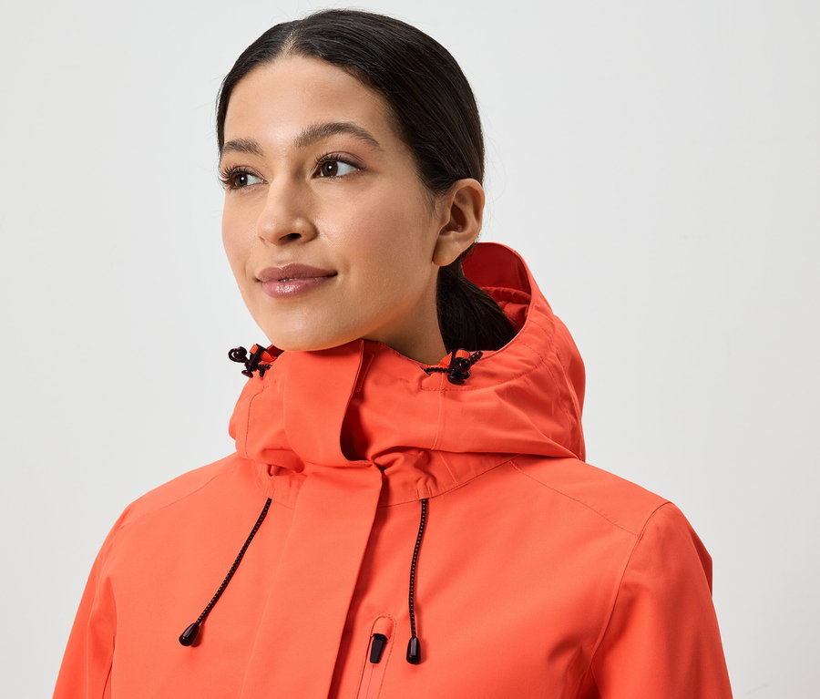 Kapüşonlu mercan rengi bir ceket giyen bir kadının portresi.