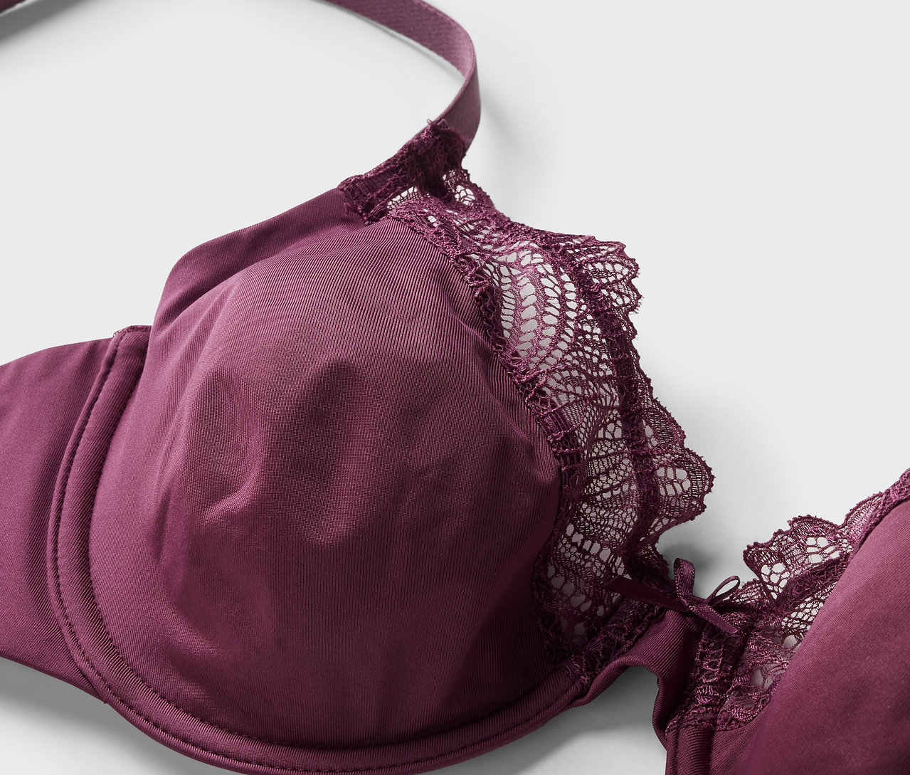 Bordo renkli, balenli ve dantelli bir sütyenin yakın çekimi.
