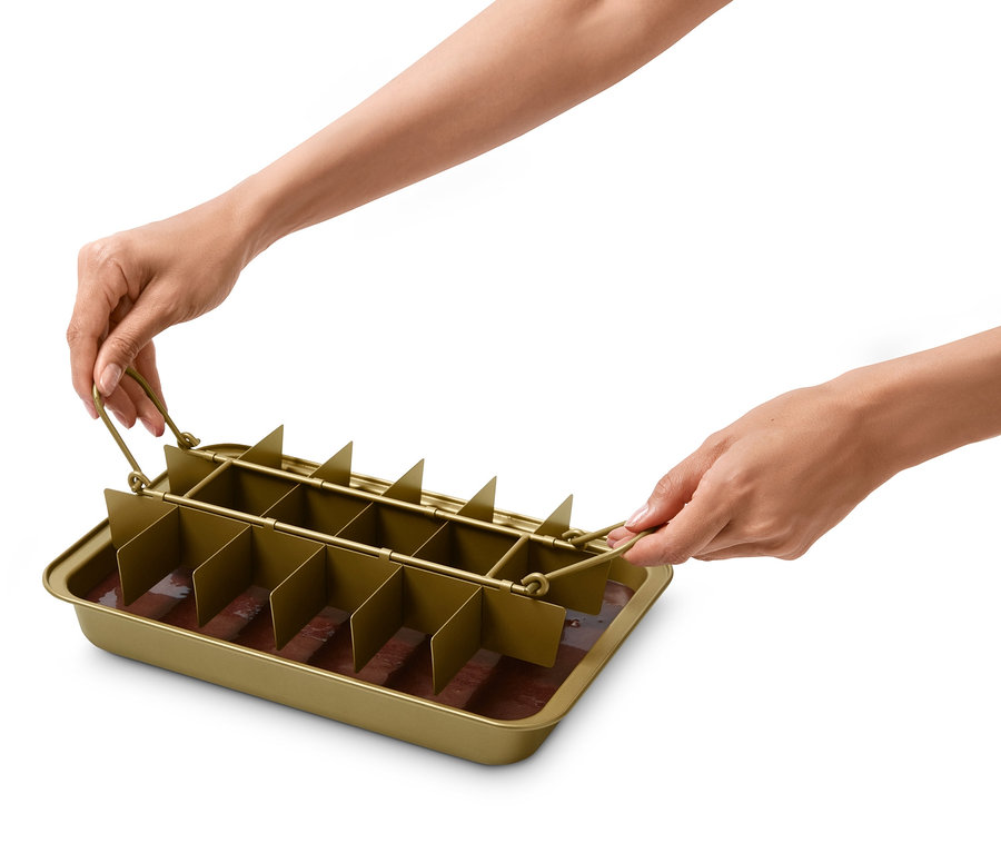 Ellerinde içinde kahverengi karışım bulunan bir Brownie Pişirme Kalıbı tutuyor.