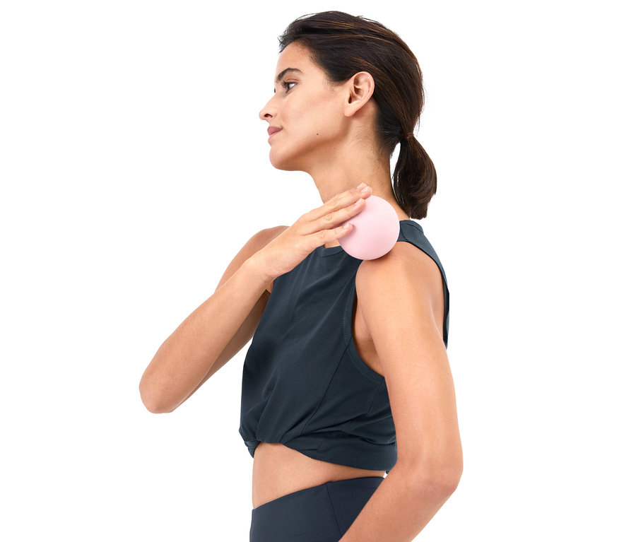 Kadın fasya masajı topuyla omzuna masaj yapıyor.