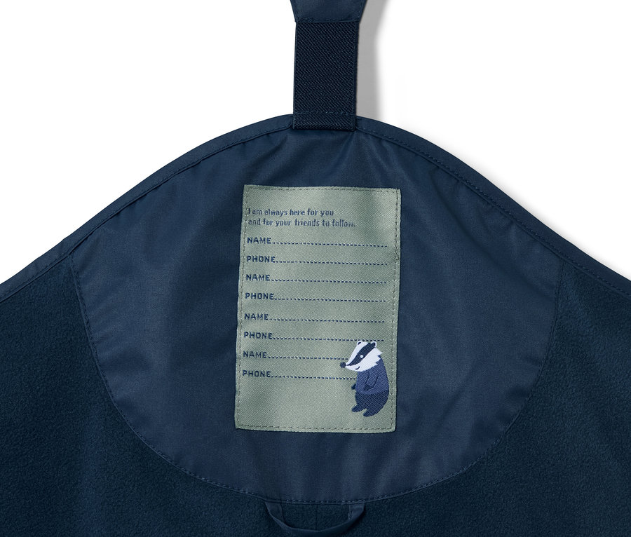 Lacivert termal yağmur pantolonunun isim ve telefon numarası etiketi detayı.