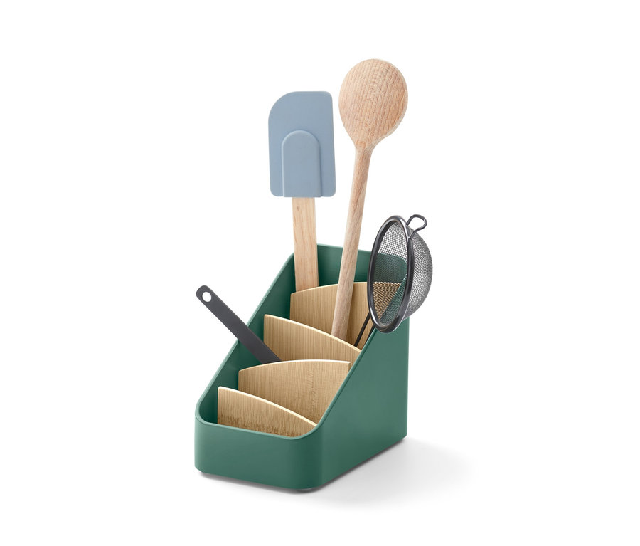 Yeşil malzeme standının içinde tahta kaşık, süzgeç ve spatula görülüyor.