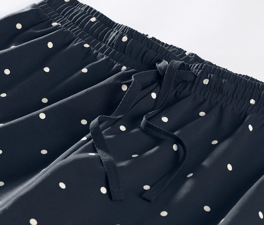 Beyaz puantiyeli ve bağcıklı, kısa bir pijama altının yakın çekimi.