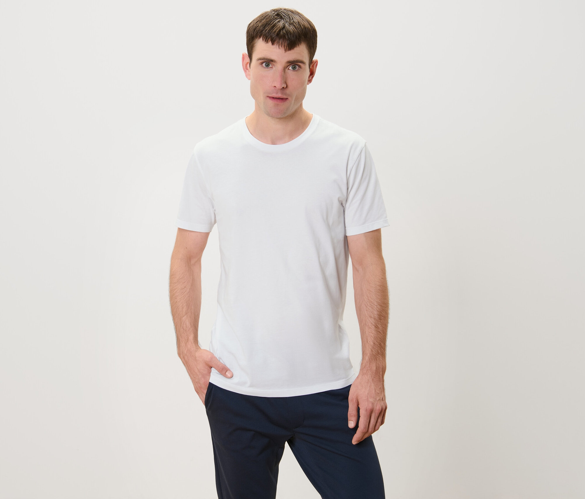 Adam beyaz 3 Adet Bisiklet Yaka Tişört ile poz veriyor.