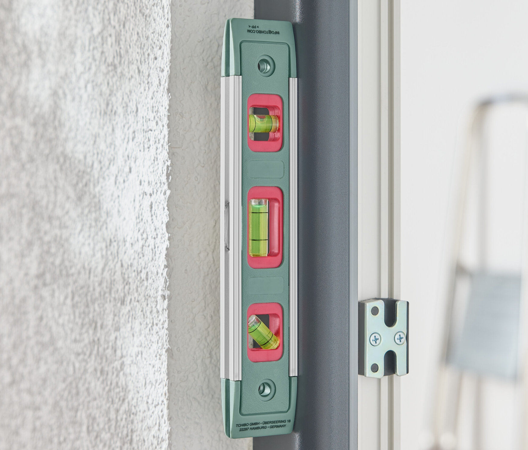 Duvara takılmış yeşil bir mıknatıslı su terazisi.