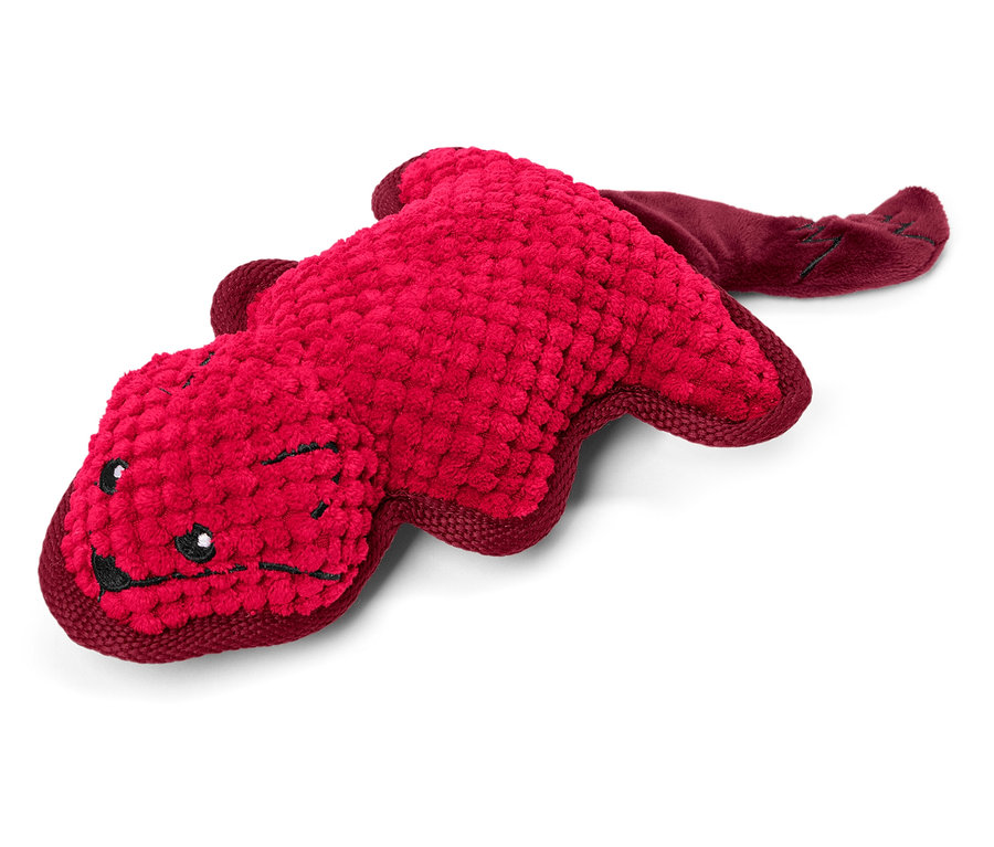 Beyaz bir arka plan üzerinde yatan hayvan şeklinde kırmızı bir peluş oyuncak.