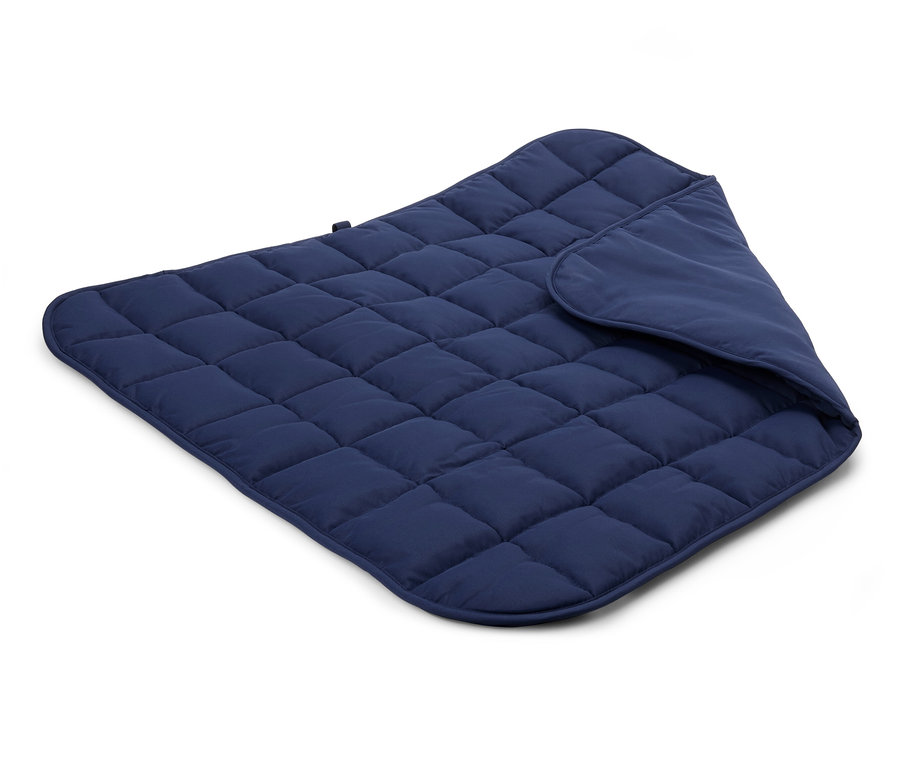 Beyaz bir arka plan üzerinde kapitone edilmiş, koyu mavi bir battaniyenin yakın çekim görüntüsü.