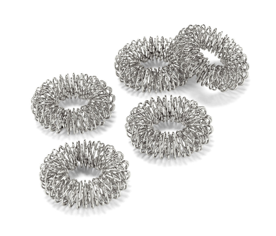 Beş adet parmak masaj yüzüğü beyaz bir zemin üzerinde duruyor.