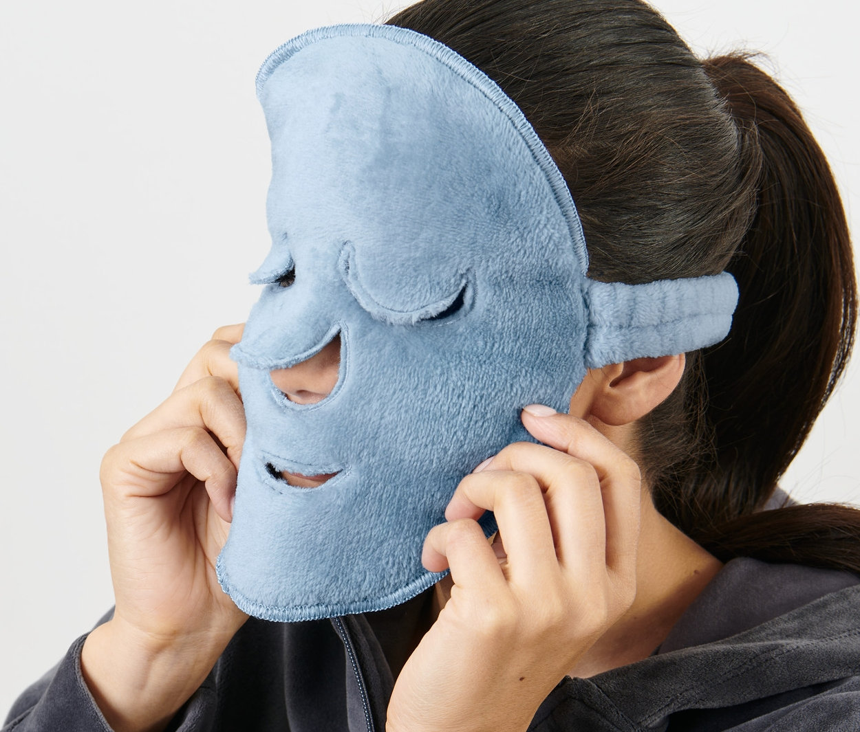 Kadın yüzüne açık mavi 2 Adet Yüz Maskesi takıyor.