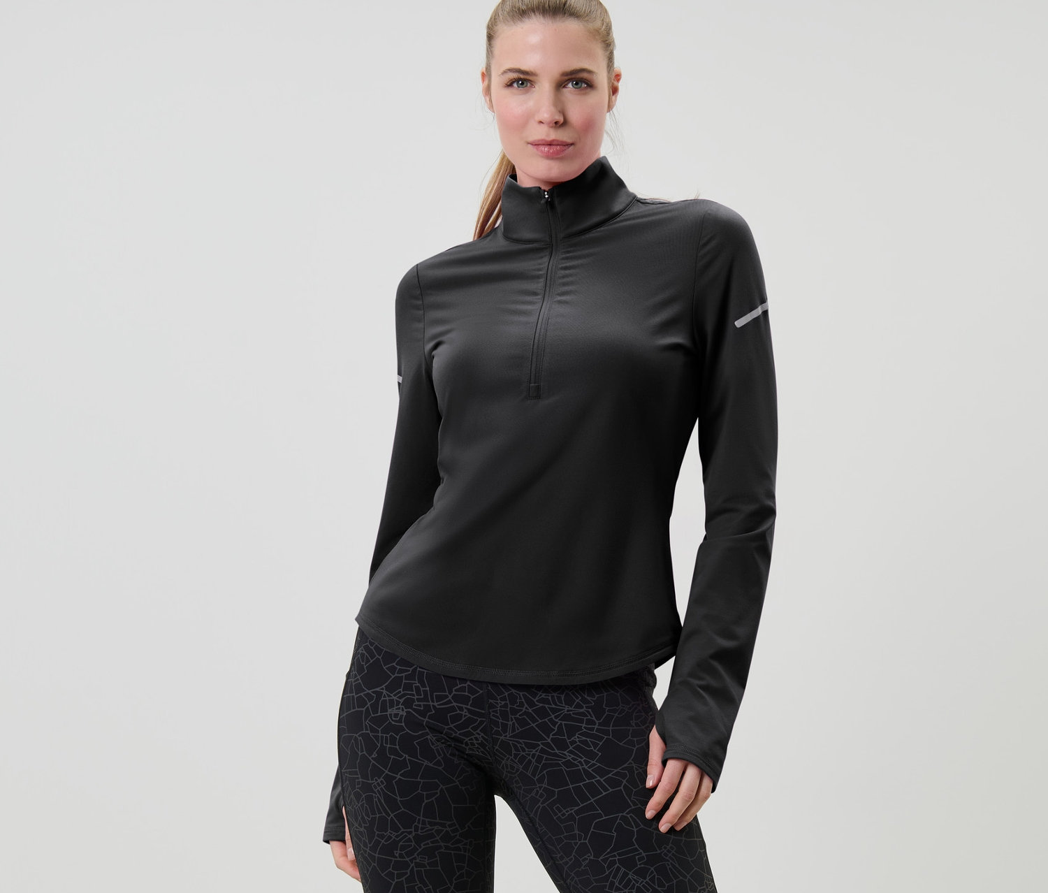 Kadın, siyah fonksiyonel termal uzun kollu tişörtle poz veriyor.
