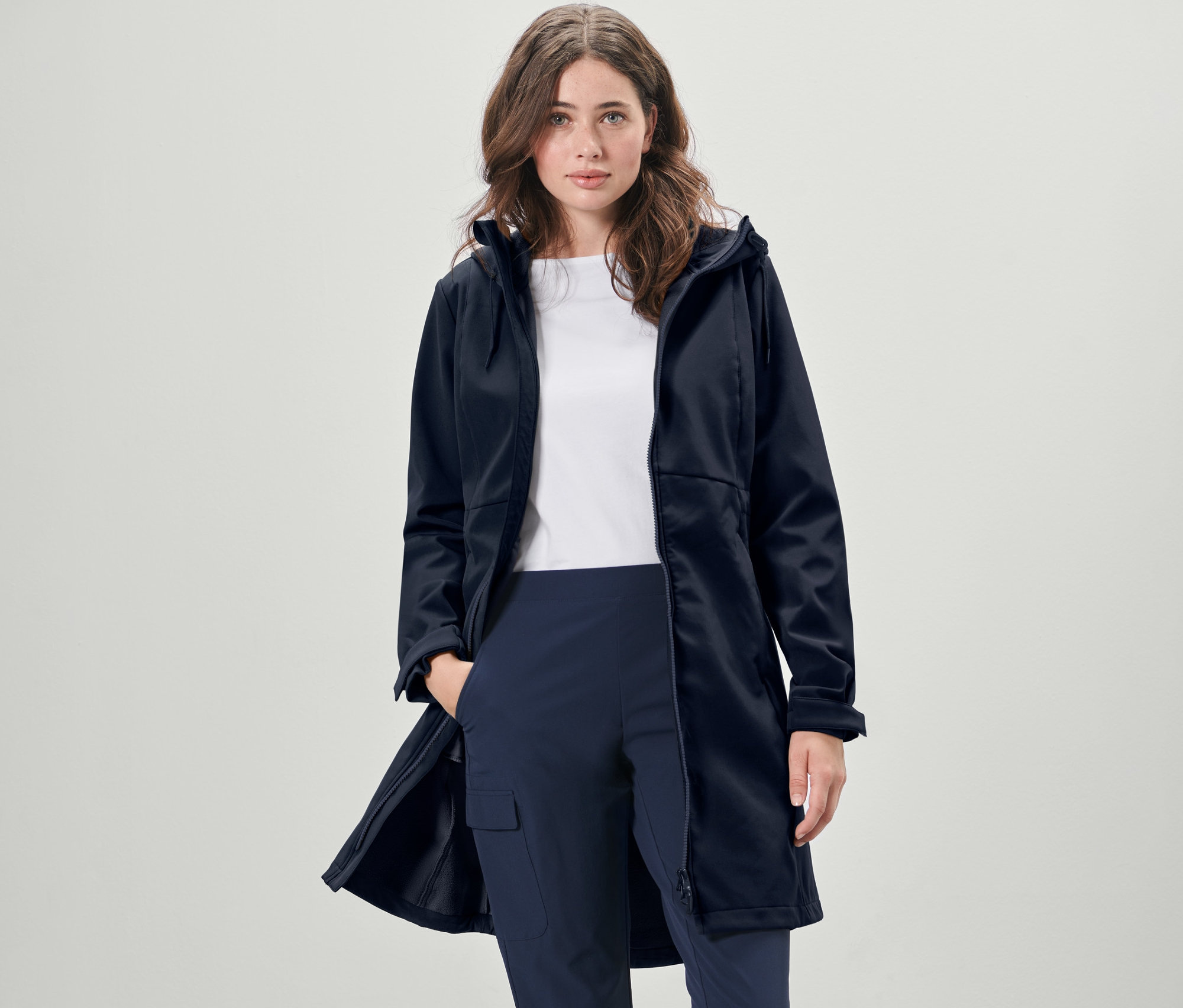 Kadın lacivert softshell palto giyiyor.