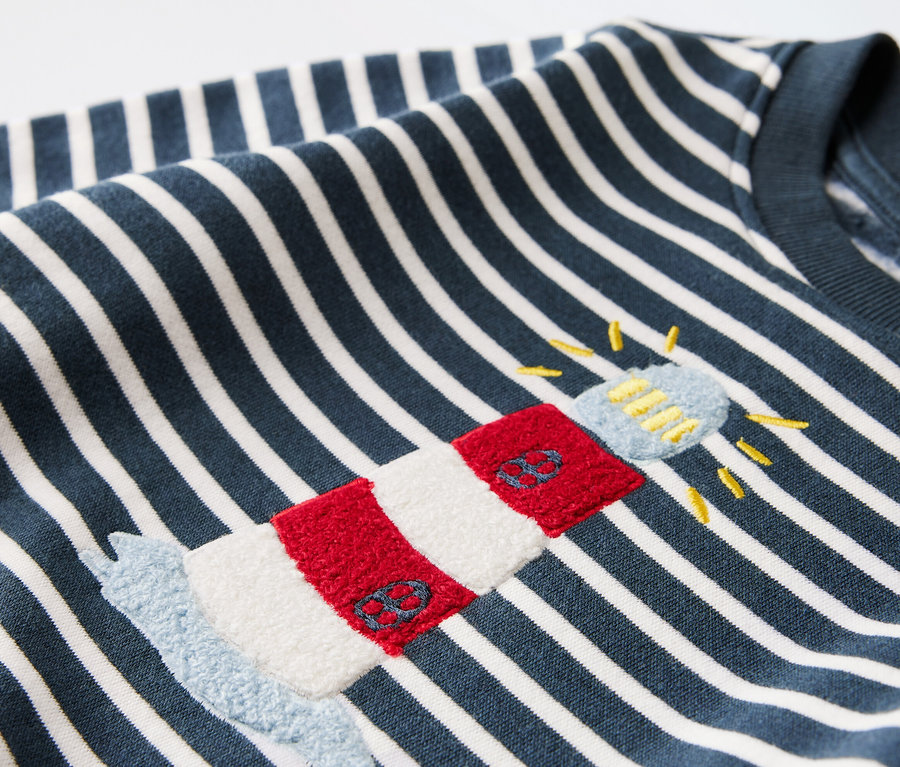 Denizci temalı ve deniz feneri aplikeli bebek sweatshirt'ün yakın çekim detayı.