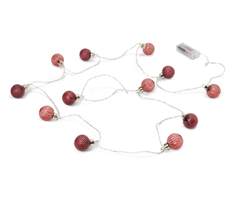 Kırmızı topları ve pilleri olan bir ışık zinciri beyaz bir arka plan üzerinde duruyor.