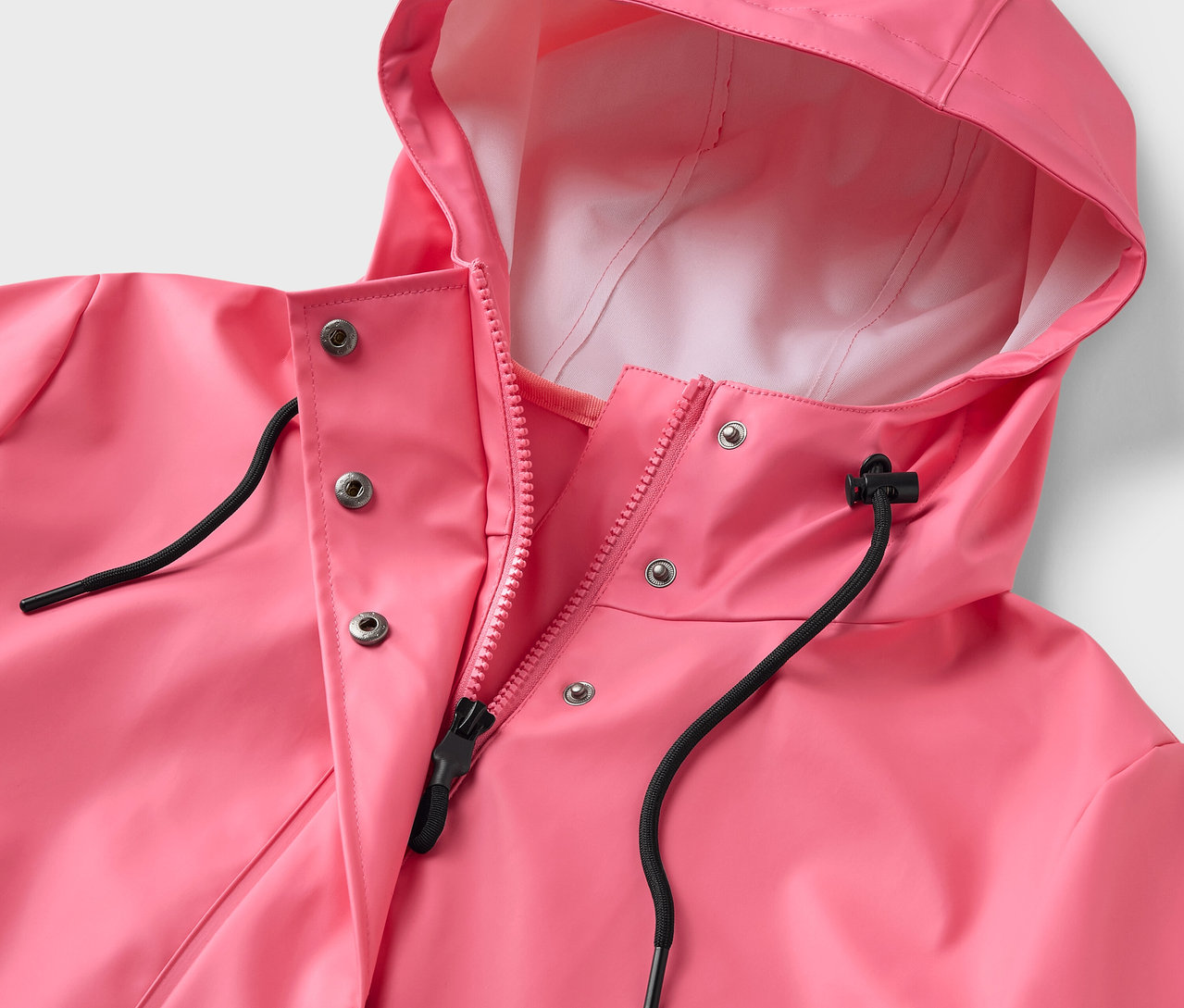 Kapüşonlu ve fermuarlı pembe bir yağmurluğun yakın çekimi.