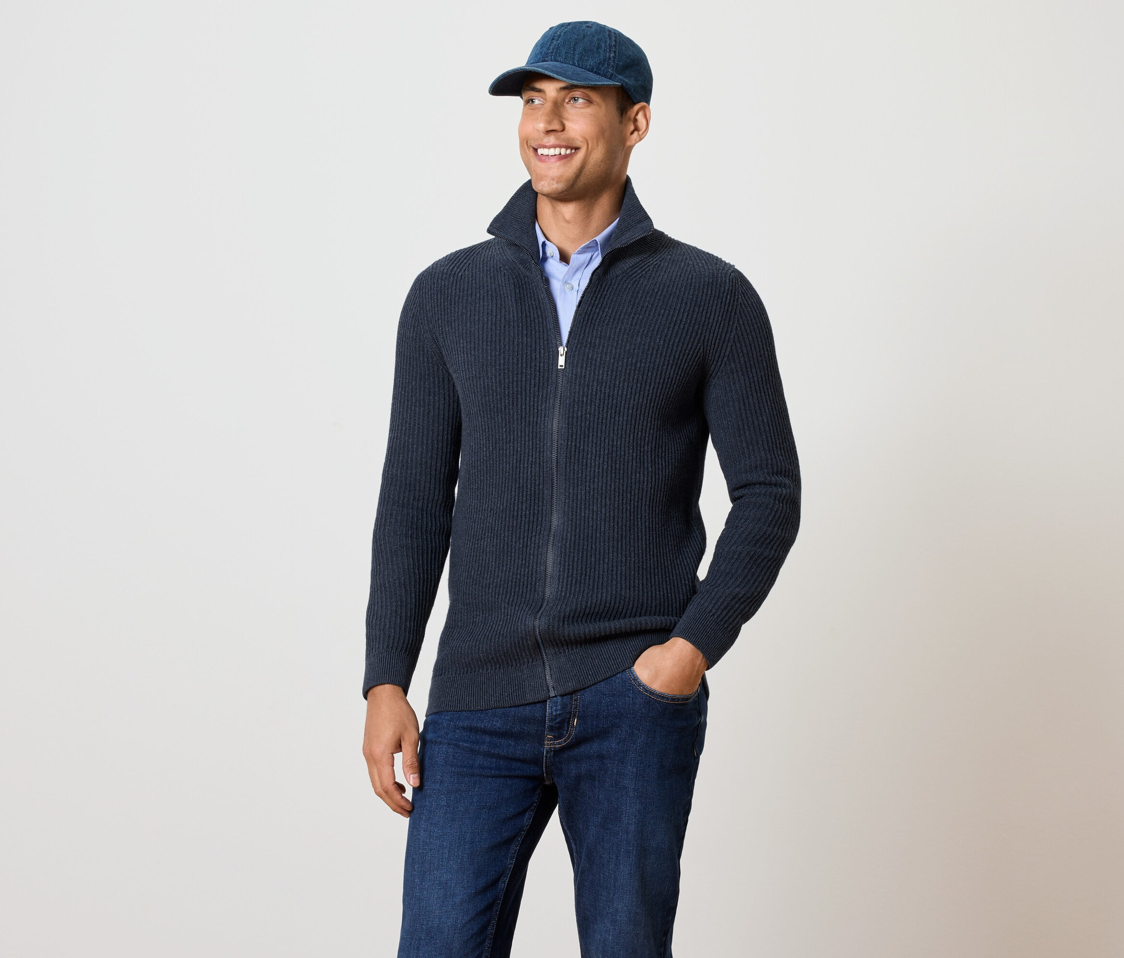 Adam lacivert bir hırka giyiyor.