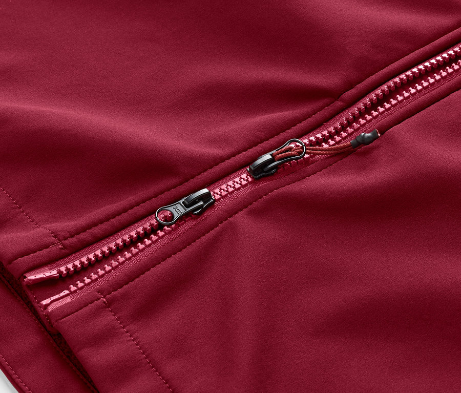 Koyu kırmızı softshell mont fermuarının detayı.