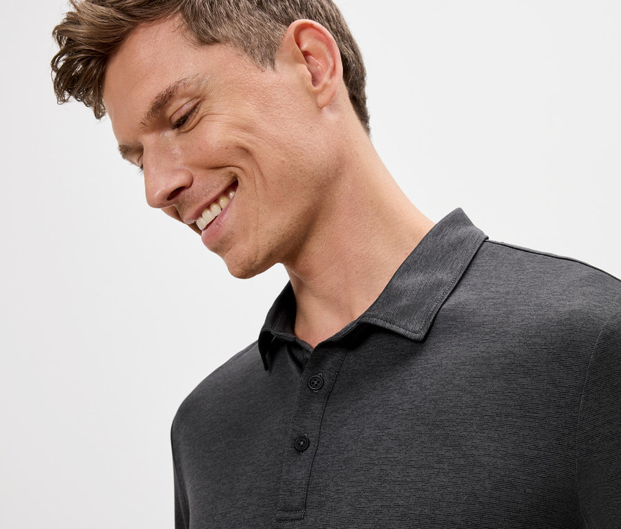 Gri renkli polo tişört giyen gülümseyen adam.