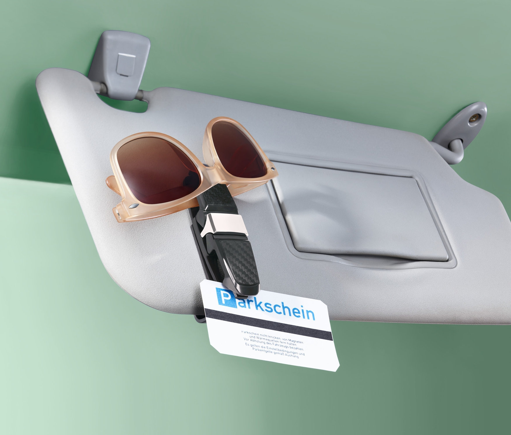 Güneşlik üzerine takılmış Araba Gözlük Tutma Klipsi içinde güneş gözlüğü.