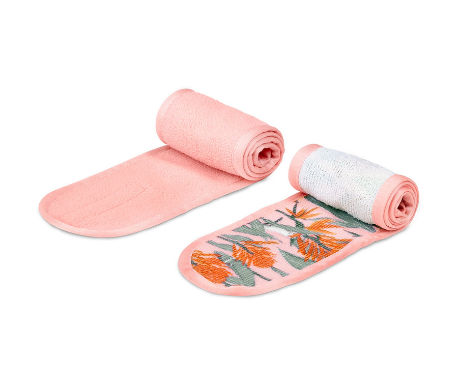 İki adet kozmetik alın bandı, biri pembe diğeri tropikal desenli, yan yana duruyorlar.