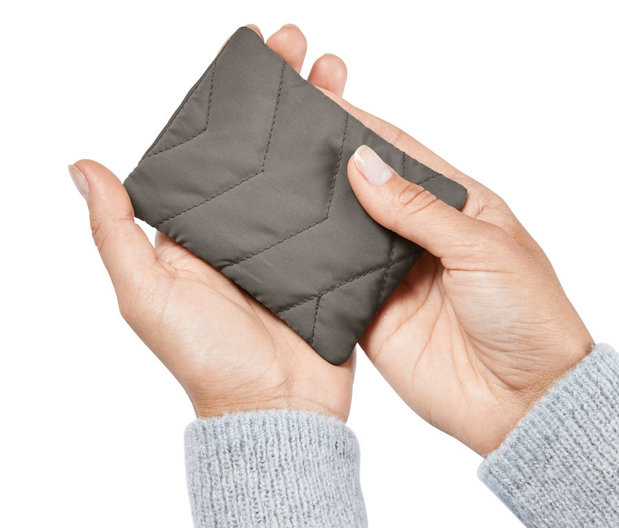 Bir kişi elinde Cep Isıtma Yastığı tutuyor.