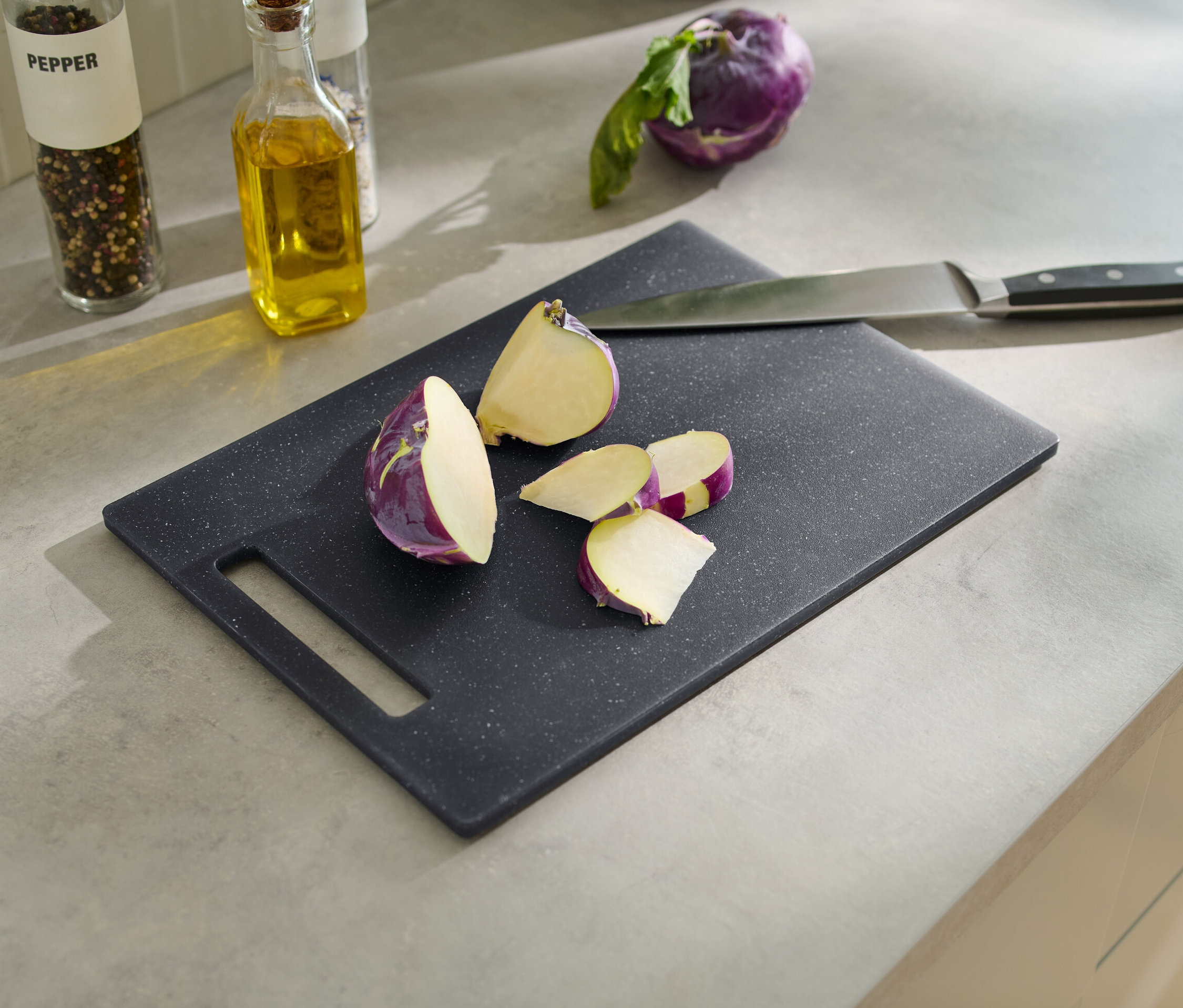 Granit görünümlü kesme tahtası üzerinde kesilmiş mor turp ve bir bıçak. 