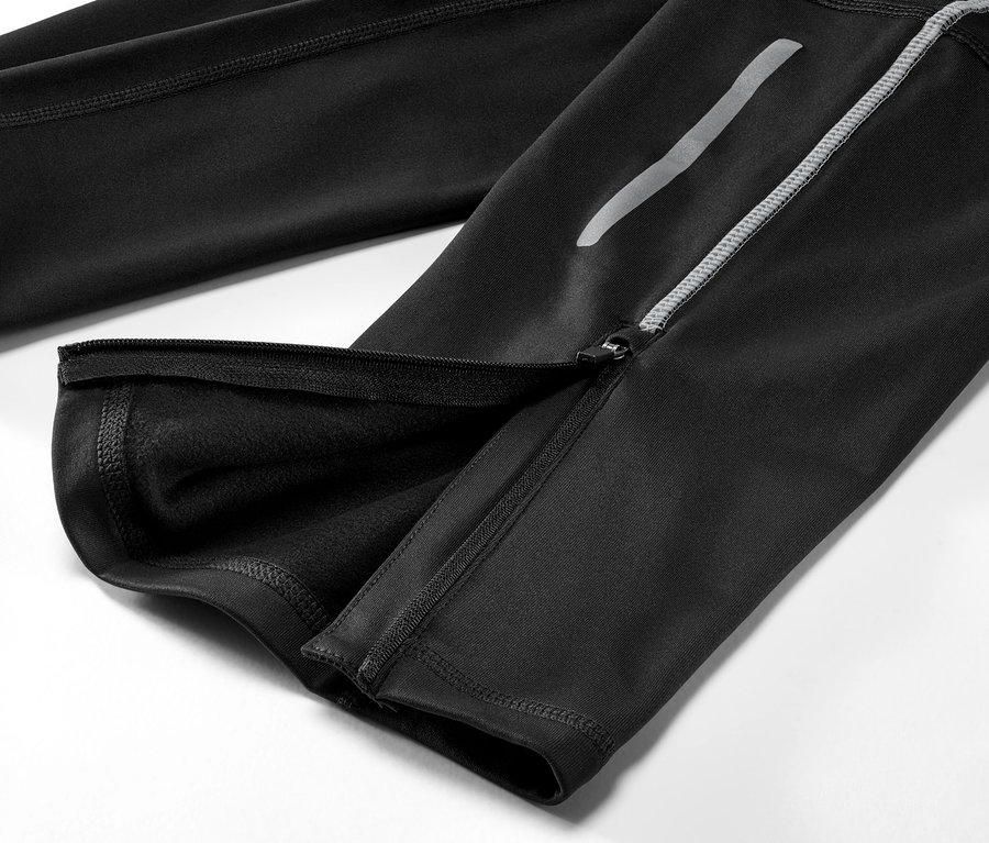 Bacağında fermuarı açılmış siyah Termal Koşu Taytı'nın yakın çekim görüntüsü.